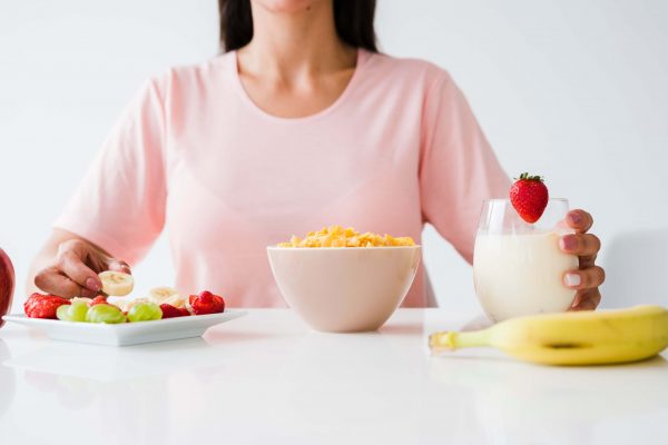 close-up-of-woman-having-healthy-breakfast-on-white-desk (1)