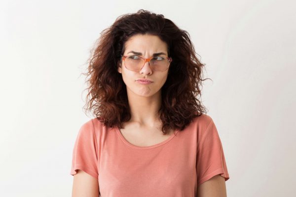 young-pretty-stylish-woman-in-glasses-thinking-pensive-face-expression-curly-hair-having-problem-funny-emotion-isolated-pink-t-shirt-student-frowning (1)